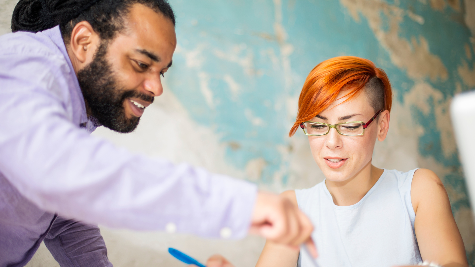 An employer showing an apprentice what to do in an office