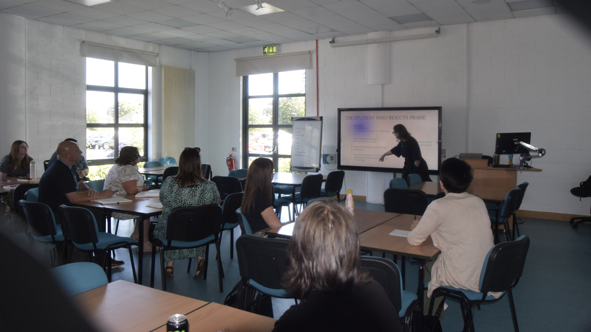 Room full of people watching a PowerPoint presentation