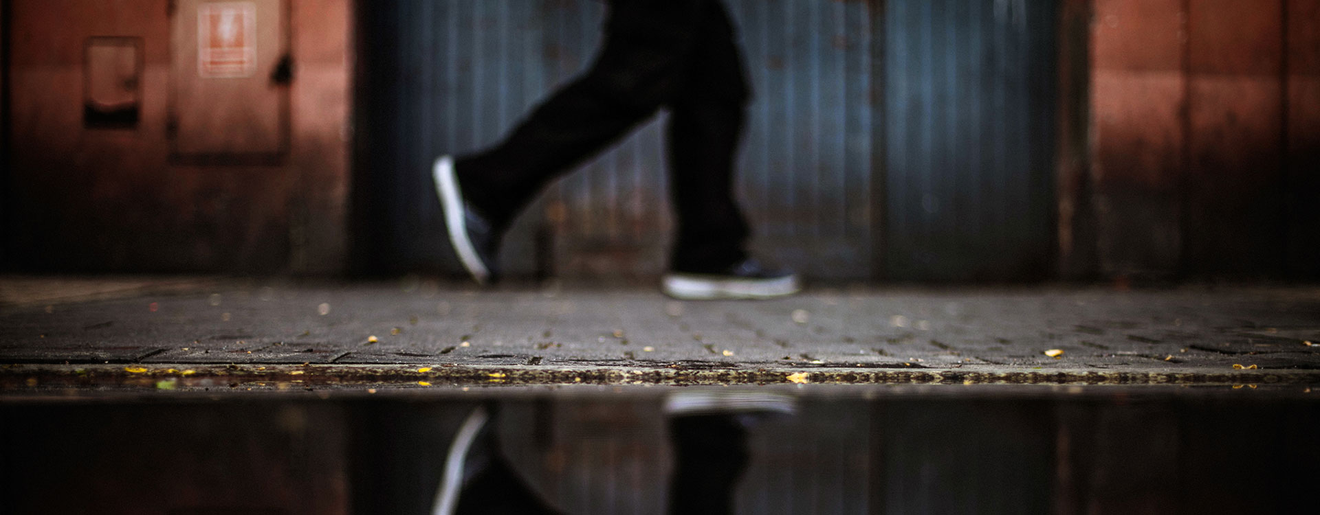 Image of a man walking with a reflection in a puddle
